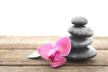 Spa stones with purple orchid on white background