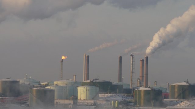A factory with blowing smoke from the chimney, winter