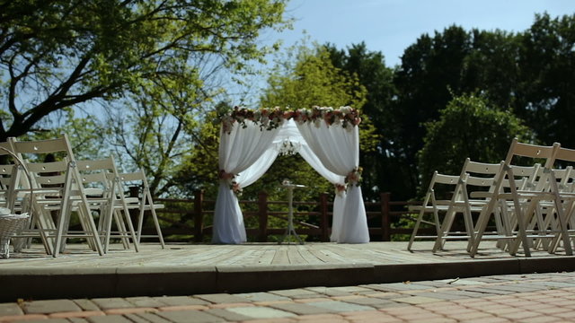 Wedding arch and white chairs in the open air