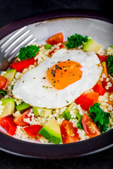 Salad with millet, avocado, cherry tomatoes and fried egg