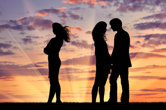 Silhouette of a lonely woman near loving couple