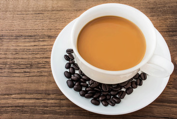 Coffee cup and beans on grunge wooden background