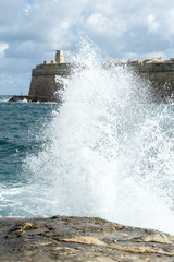The waves beat against the rocky shore in Malta