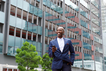 Businessman walking with  cell phone in the city