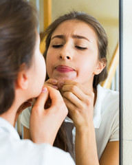 Girl squeezing pimple