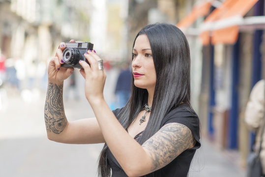 Hipster woman taking pictures with classica camera.