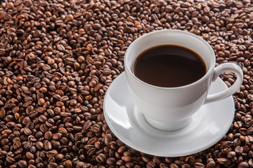white cup of black coffee on beans