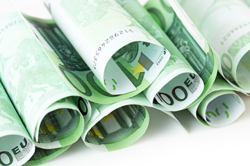 100 euro banknotes rolled up on white background