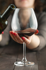 Close-up of alcoholic's hands pouring red wine