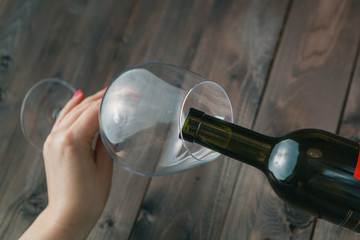 Female take wine glass on dark toned table