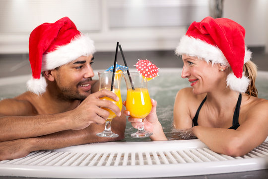 Happy christmas santa couple in hot tub. Vacation