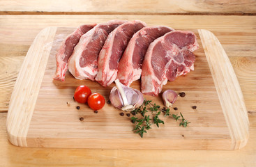 Raw meat lamb entrecote on bone on a wooden board