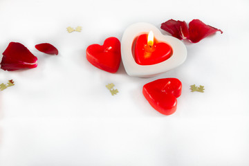Valentines Day heart shaped candles and rose petals on white bac