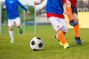 Fototapeta na wymiar Young Boys Playing Soccer Football Match on a Sports Field