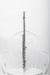 флейта на белом металлическом стуле