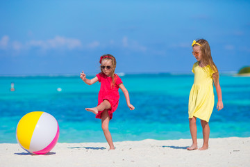 Little adorable girls playing with ball on the beach