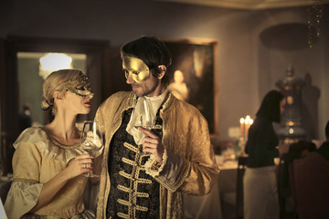 Masked couple drinking wine