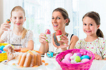 Familie mit Mutter und Kind färbt Eier zu Ostern