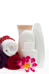 White bottle, flower and beads with towels