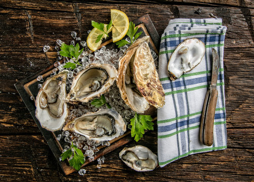 Oysters served on wooden board with ice drift