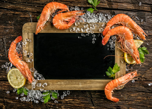Prawns served on wood with blackboard