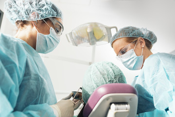 Dentists with a patient during a dental intervention.