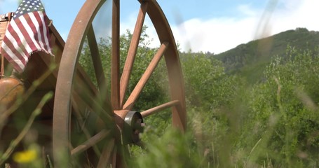 A pioneer handcart sits in a beautiful mountain meadow. 