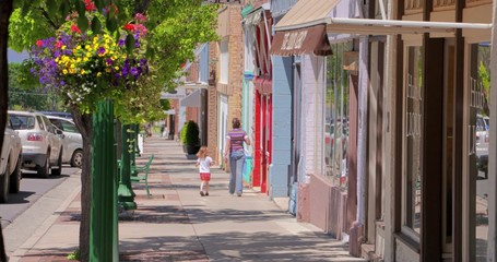 People walk down a beautiful small town sidewalk.
