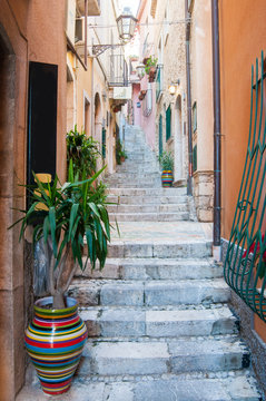A characteristic narrow alley of Taormina, Eastsicily, with some typical colored ceramic vases