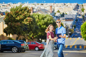 Obraz premium Romantic couple of tourists using tablet in San Francisco, California, USA