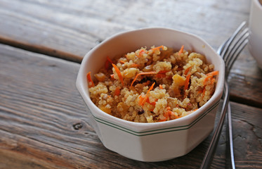 Quinoa and carrot salad sitting a wooden table.