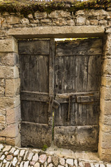 Fototapeta na wymiar Vieille porte en bois à Puycelsi, village médiéval et bastide