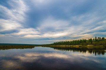 Summer day landscape with river and forest and cloudy sky 