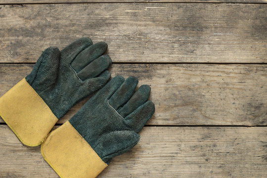 Old Dirty Leather Work Gloves On Wood Background