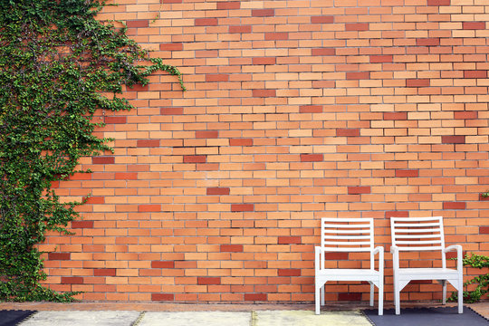 Chair wood with wall blick and tree plant on background.