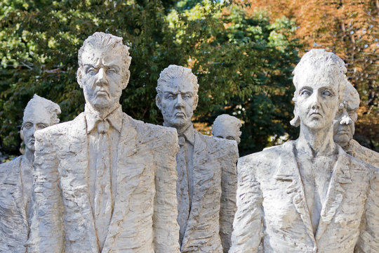 Sculpture of people in business suits on the background of trees