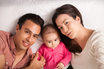 Beautiful Latin family lying on a bed