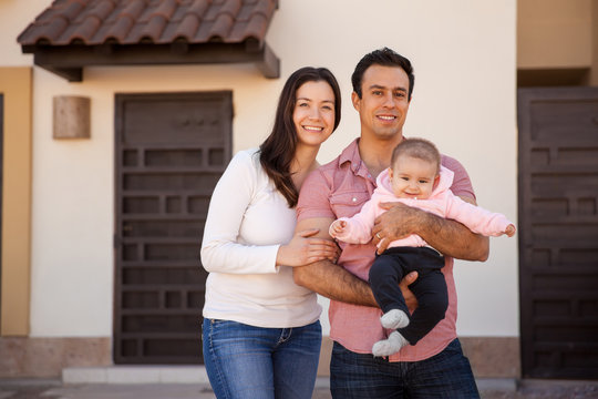 Hispanic couple and baby in their new home