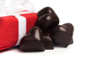 Red present box with white ribbon and candies isolated on white