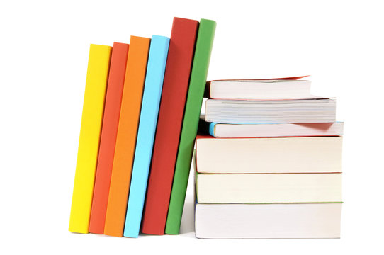 Small pile stack and leaning row line of colorful books isolated on white background school college library photo