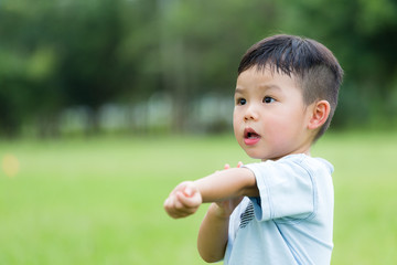 Young boy feeling itchy and scratching his arm