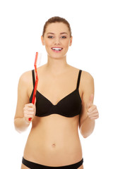 Woman holding red huge toothbrush