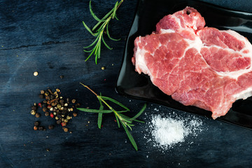  Raw fresh meat  with rosemary, pepper and salt on wooden background