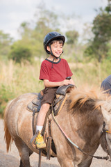 Little boy riding training horse