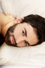 Fototapeta premium Young muscular man lying in bed.