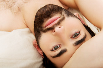 Naklejka premium Young muscular man lying in bed.