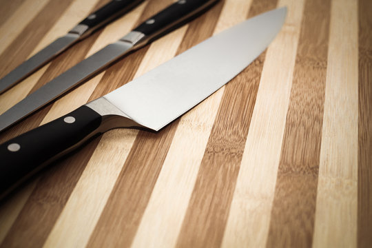 chef's knife and  other smaller knives on  cutting board