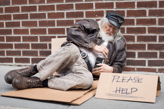 Homeless man sitting on a street with sign.Homeless lying