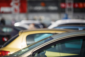 Close-up of cars on blur bokeh background. Cars in the parking lot. Shallow depth of field. Selective focus.