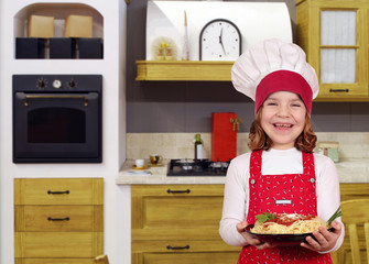 beautiful happy little girl cook with spaghetti in kitchen